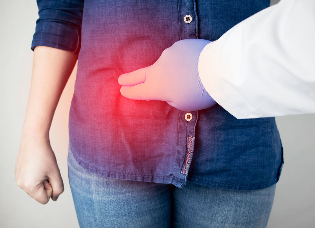 medico colocando o dedo na barriga de uma paciente